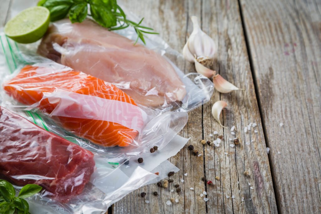 Vacuum-sealed chicken, salmon, and beef portions prepared for refrigerated processing review