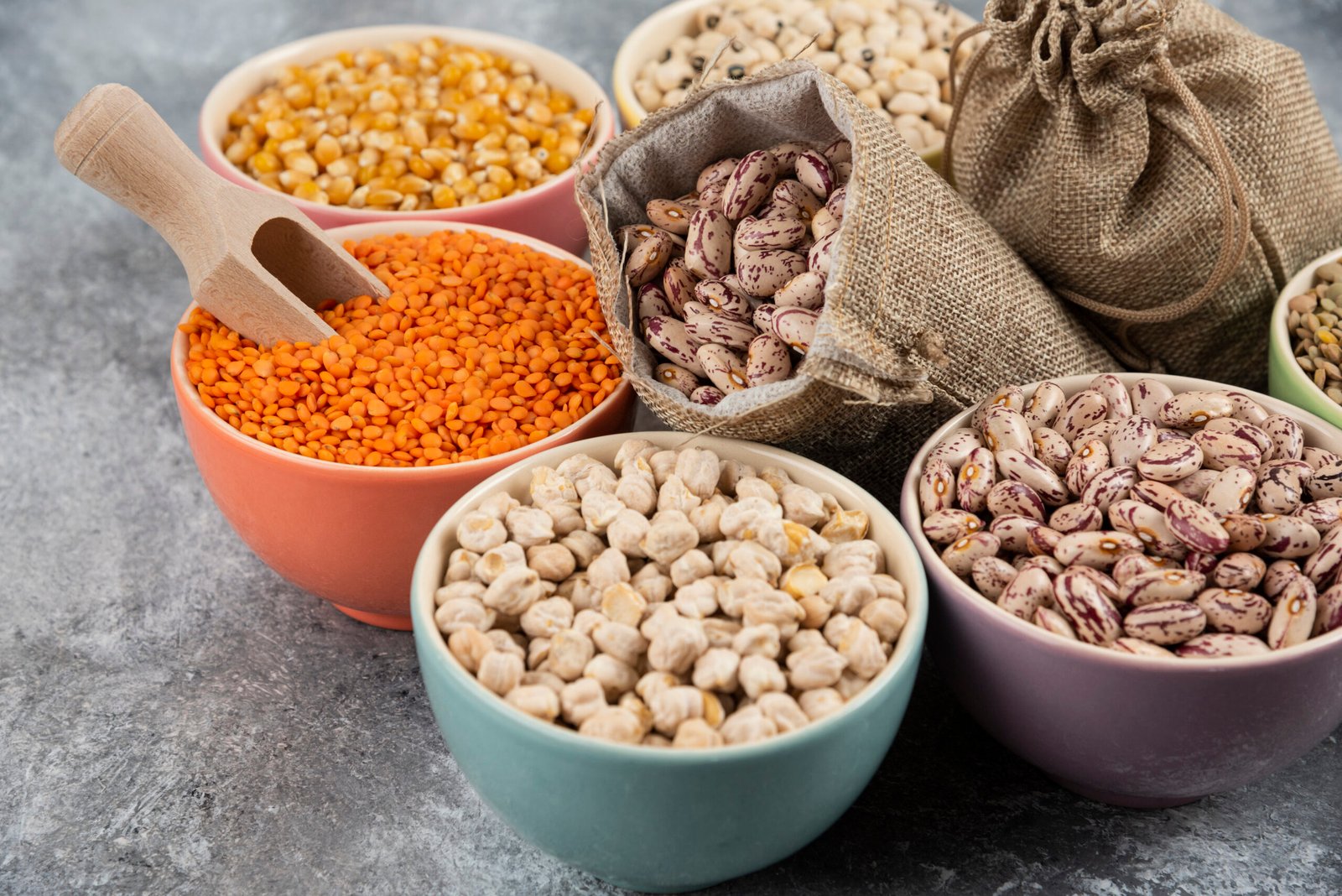Unbranded bowls and sacks of colorful dry legumes representing low-moisture products usually not suited to HPP