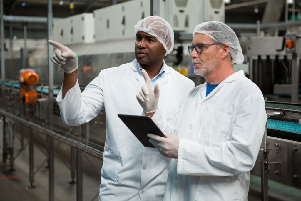 Two food production team members reviewing operations beside HPP processing equipment