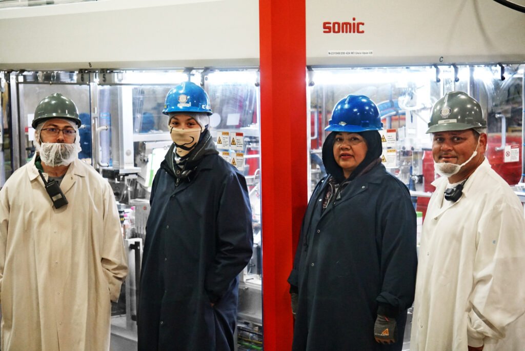 Four APC team members inside the company’s packaging facility