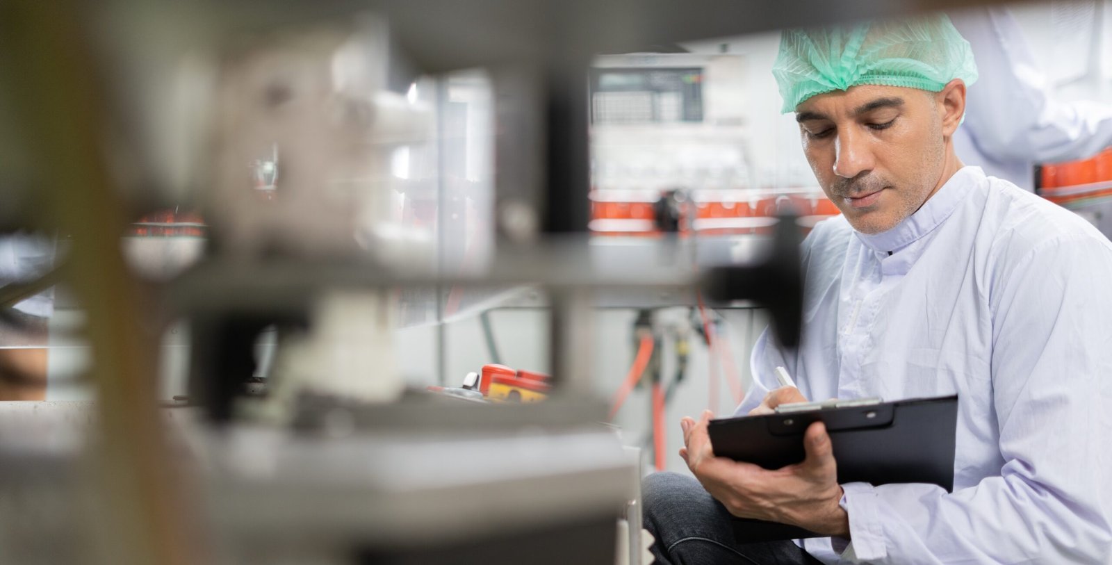 Quality-control specialist recording observations in a food processing facility