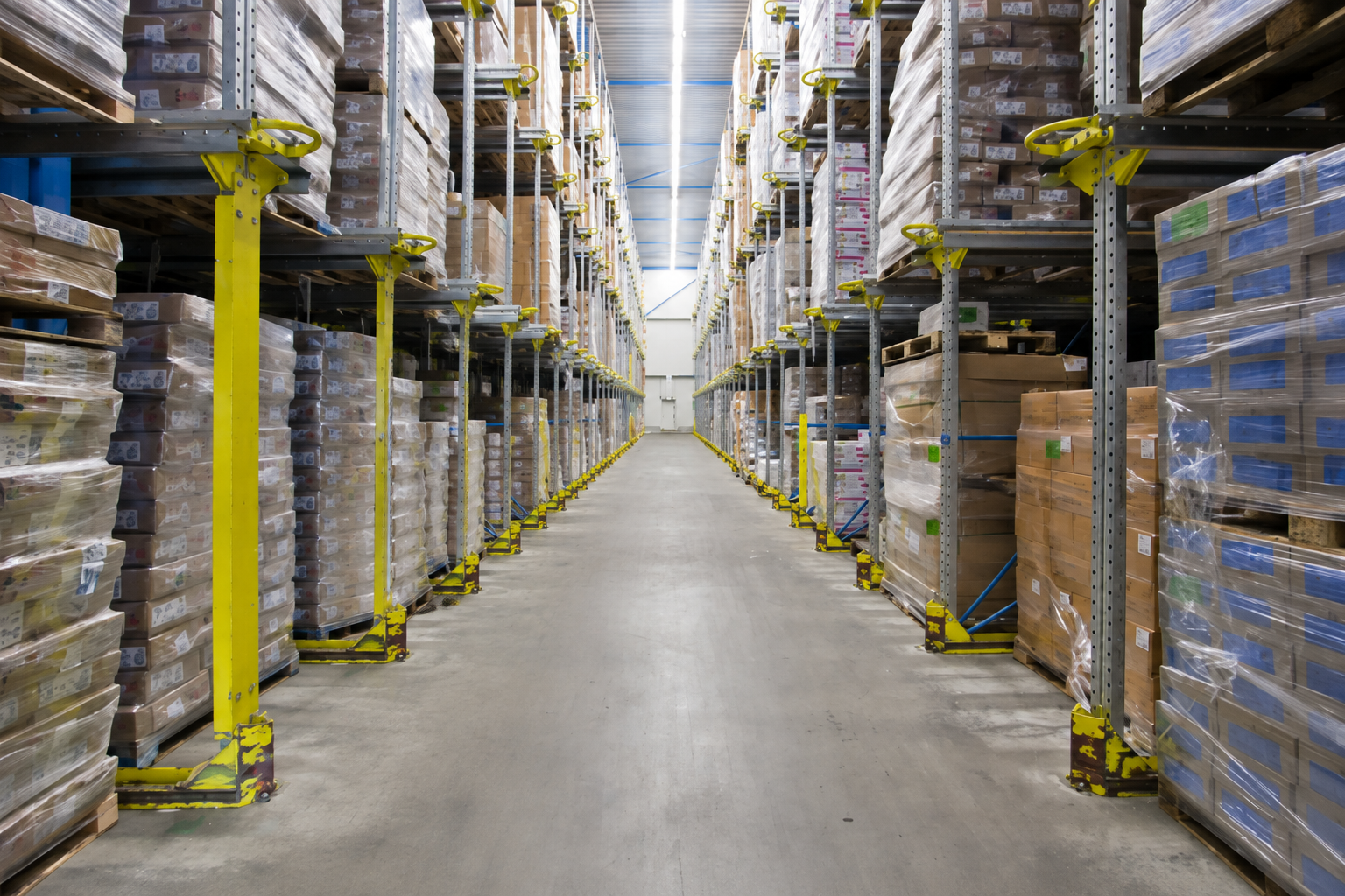 Warehouse storage aisle with tall pallet racks and stacked inventory